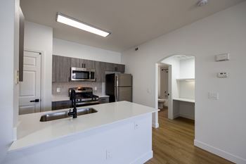 A kitchen with a white counter top and stainless steel appliances.